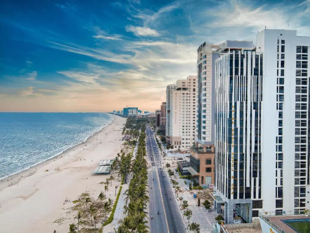 Tall HAIAN hotel building on the coast along a sandy beach and seaside boulevard