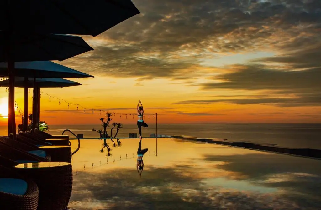 Rooftop infinity pool overlooking the ocean during a golden sunset