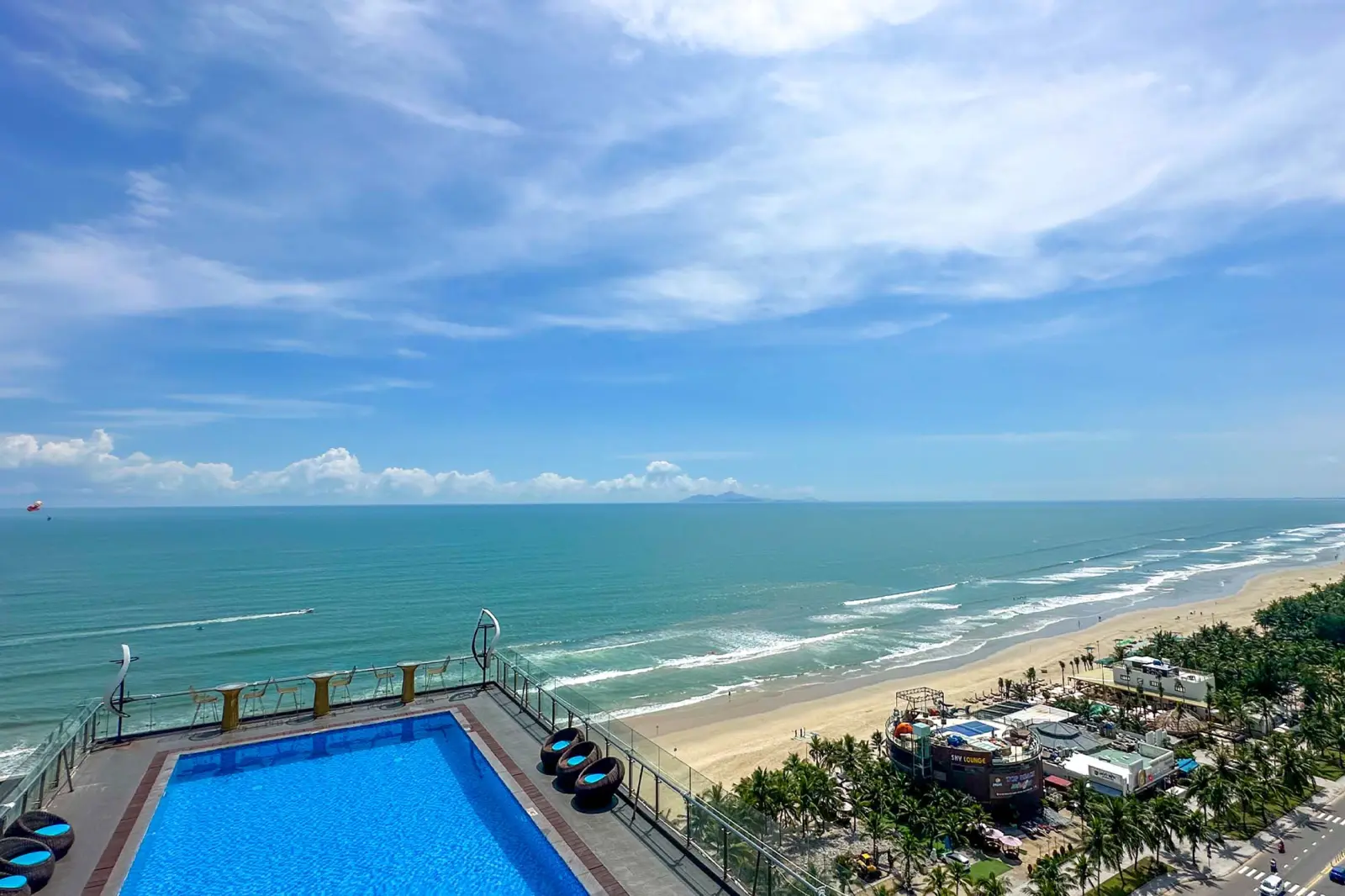 Rooftop swimming pool with panoramic views of the ocean and sandy beach.