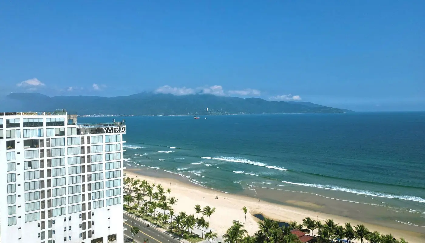 Yarra Ocean Suites hotel building on the coast with views of the sandy beach and sea in Da Nang.