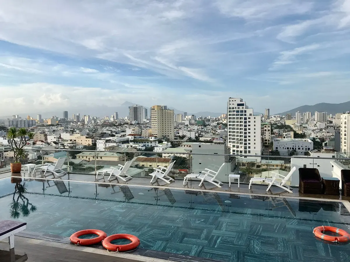 Rooftop swimming pool with sun loungers and a panoramic view of the city