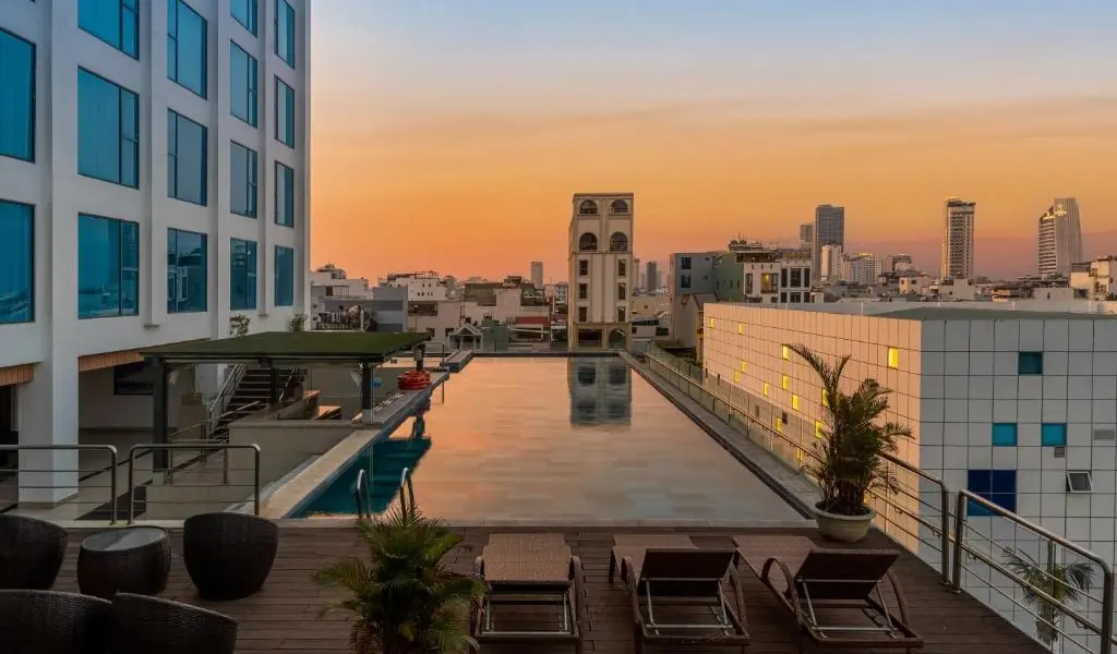 Rooftop infinity pool overlooking the city skyline at sunset.