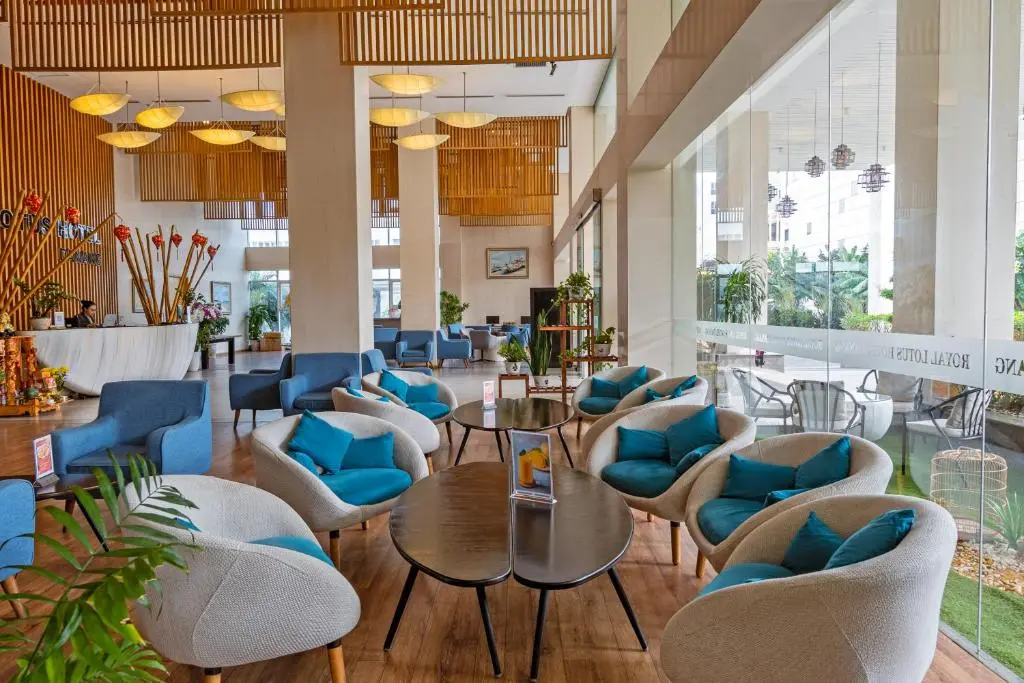 Cozy hotel lobby lounge with modern armchairs and decorative wooden ceiling slats.