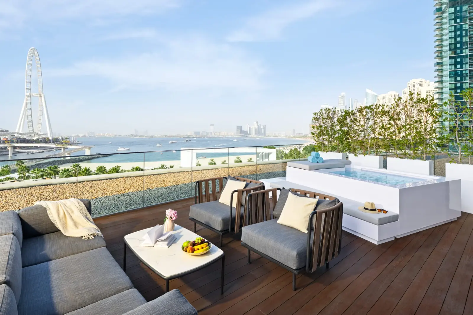 Hotel terrace with lounge seating and a small pool overlooking a Ferris wheel