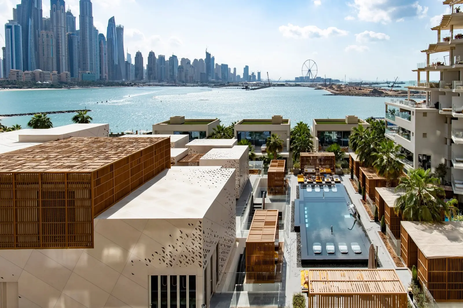 Overhead view of the hotel outdoor pool, the gulf, and the Dubai skyline.