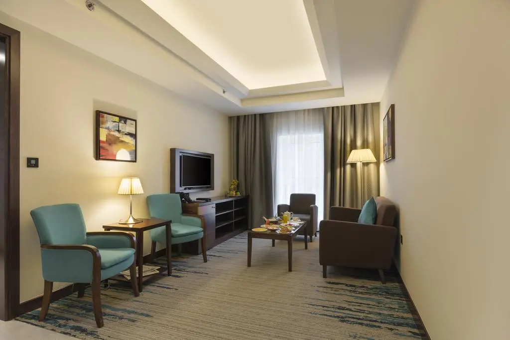 Spacious living area in a hotel suite with armchairs and a coffee table