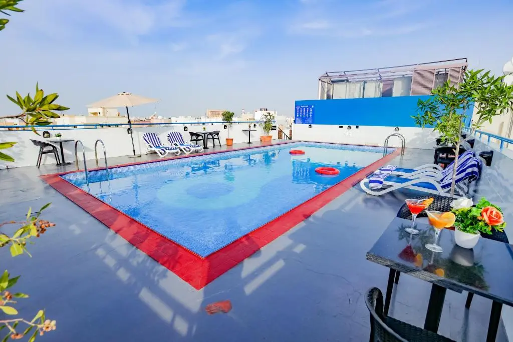 Outdoor rooftop swimming pool with sun loungers.